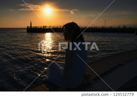 Woman watching the sunset at the harbor Woman watching the sunset at the harbor 120532779
