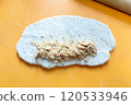 Nuts are placed on the rolled out bagel dough. 120533946