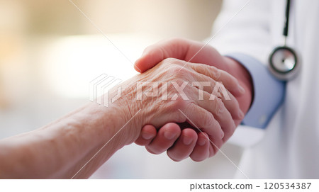 Heartwarming medical scene of elderly patient and doctor shaking hands 120534387