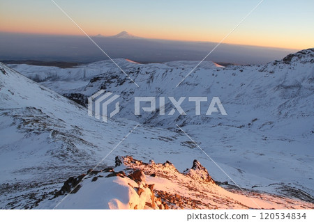Stunning Snowy Mountain Landscape with Clear Blue Sky and Prominent Peak in the Distance 120534834