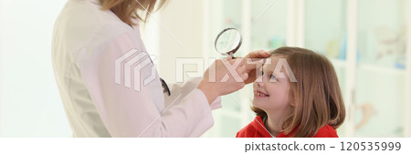 Optometrist examining little girl eye in doctor premise Optometrist examining little girl eye in doctor premise 120535999