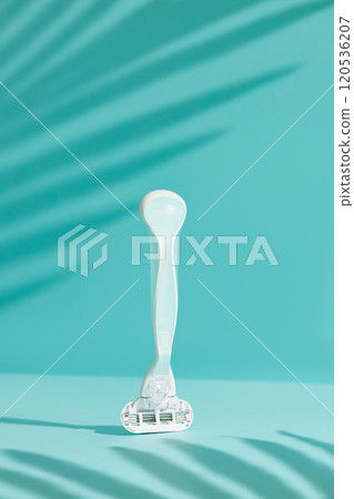 Minimalist elegance: Razor in sharp relief against a bold blue backdrop with dramatic shadows Minimalist elegance: Razor in sharp relief against a bold blue backdrop with dramatic shadows 120536207