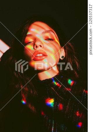 Playful, colorful stripes of light dance across a womans face, creating a dreamy, surreal effect Playful, colorful stripes of light dance across a womans face, creating a dreamy, surreal effect 120537317