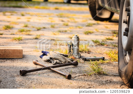 Socket wheel wrench and jack lying on ground Socket wheel wrench and jack lying on ground 120539829