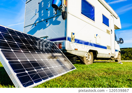 Camper with portable solar panel on coast 120539867