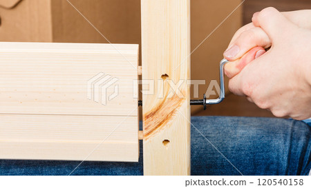 Assembling wood furniture using hex key. DIY. 120540158