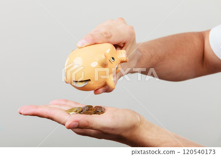 Male hands with coins and piggybank 120540173