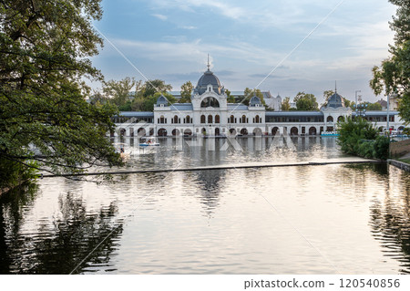 Budapest, Hungary. August 27, 2022. Shot of the City Park Ice Rink and Boating, the building stretches along the body of water navigated by tourist boats in the summer. Beautiful summer day. Budapest, Hungary. August 27, 2022. Shot of the City Park Ice Rink and Boating, the building stretches along the body of water navigated by tourist boats in the summer. Beautiful summer day. 120540856