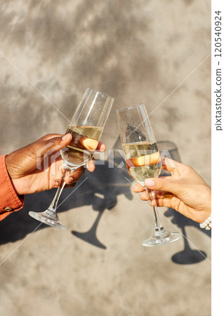 Two individuals clinking champagne glasses against light background, celebrating special moment shared in bright setting without any distractions Two individuals clinking champagne glasses against light background, celebrating special moment shared in bright setting without any distractions 120540924