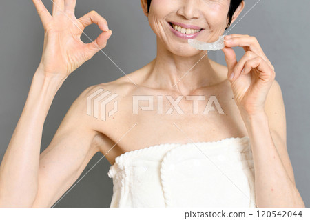 A middle-aged woman holding a mouthpiece and saying OK A middle-aged woman holding a mouthpiece and saying OK 120542044