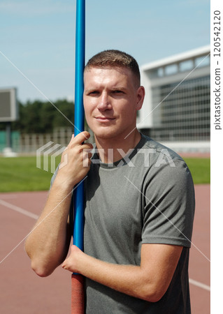 Portrait of Man Holding Pole on Track with Building Behind Portrait of Man Holding Pole on Track with Building Behind 120542120