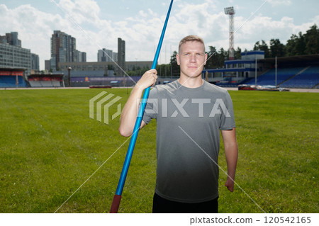 Holding Javelin on Athletic Field Under Cloudy Sky 120542165