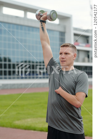 Lifting Dumbbell Outdoors Near Glass Building Lifting Dumbbell Outdoors Near Glass Building 120542177