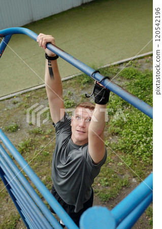 Man Exercising on Outdoor Fitness Equipment Man Exercising on Outdoor Fitness Equipment 120542196