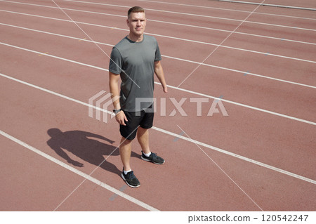 Running Athlete Standing on Track Field Preparing for Training Running Athlete Standing on Track Field Preparing for Training 120542247