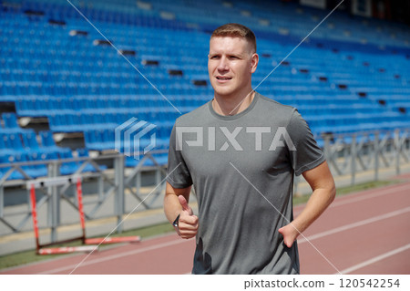 Jogging on Track at Outdoor Athletic Stadium Jogging on Track at Outdoor Athletic Stadium 120542254