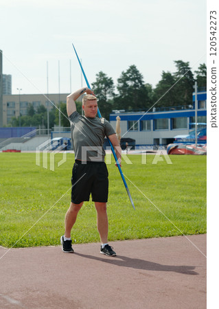 Athlete Practicing Javelin Throw on Sports Field Athlete Practicing Javelin Throw on Sports Field 120542273