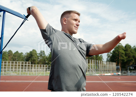 Stretching with Exercise Band on Athletic Track Stretching with Exercise Band on Athletic Track 120542274