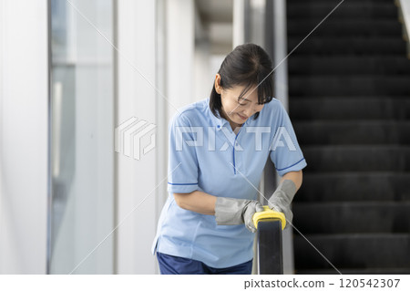 中年女清潔員擦拭手扶梯扶手 中年女清潔員擦拭手扶梯扶手 120542307