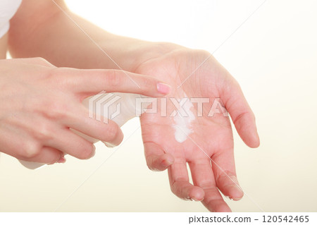 Woman putting white cream on hand 120542465