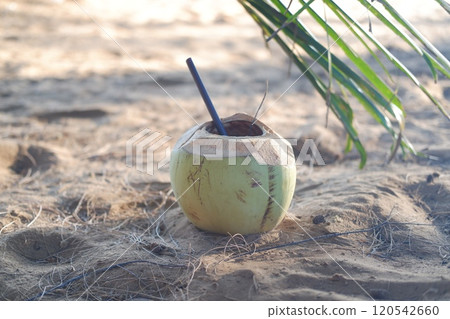 Coconut with straw on the beach. Selective focus. Coconut with straw on the beach. Selective focus. 120542660