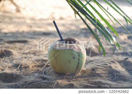Coconut with straw on the beach. Selective focus. Coconut with straw on the beach. Selective focus. 120542662