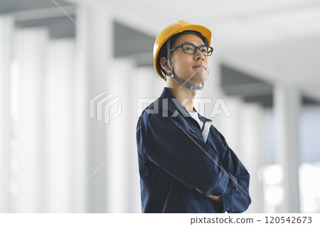 一名40多歲的男子,戴著頭盔,穿著工作服 一名40多歲的男子,戴著頭盔,穿著工作服 120542673