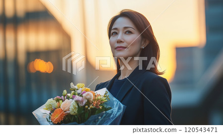 日本婦女在退休日手捧鮮花 120543471