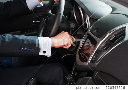 Man pressing engine ignition button in a modern car on the control panel. Man pressing engine ignition button in a modern car on the control panel. 120543516