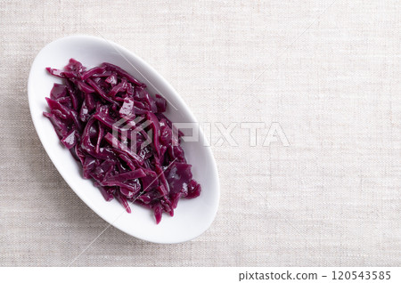 Braised red cabbage in a white bowl, with empty space for text. Traditional German side dish of intense purple color made of sliced cabbage, simmered slowly, and in Christmas time cooked with spices. 120543585