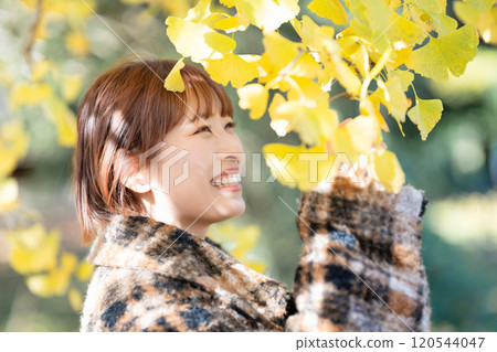 Young woman enjoying autumn leaves hunting 120544047