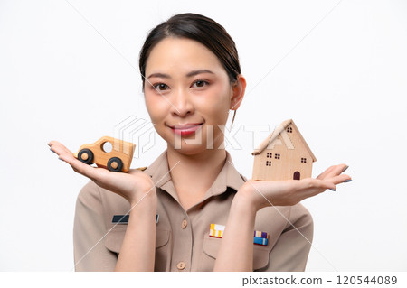 Young Thai Asian Teacher in the uniform is holding wooden house and car toy Young Thai Asian Teacher in the uniform is holding wooden house and car toy 120544089