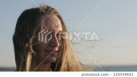 closeup portrait of young girl standing on a beach and wind blows her hair closeup portrait of young girl standing on a beach and wind blows her hair 120544681