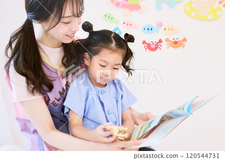 保育老師與幼兒園小朋友一起閱讀繪本 保育老師與幼兒園小朋友一起閱讀繪本 120544731