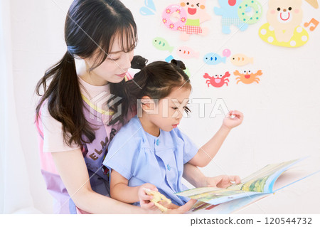 保育老師與幼兒園小朋友一起閱讀繪本 120544732