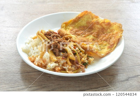 spicy stir fried bamboo shoot and slice beef meat with basil leaf topping Thai egg omelette on rice in plate spicy stir fried bamboo shoot and slice beef meat with basil leaf topping Thai egg omelette on rice in plate 120544834