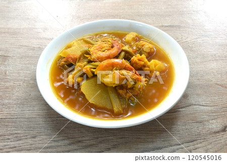 boiled shrimp and mixed vegetable in spicy and sour orange curry soup on plate  120545016