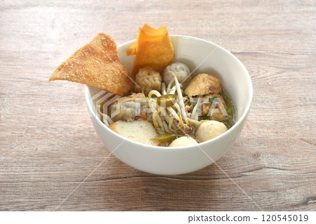 boiled Hakka meatball made from chop pork stuffing fried tofu with bean sprout and fish ball topping crispy dumpling in spicy tom yum soup on bowl boiled Hakka meatball made from chop pork stuffing fried tofu with bean sprout and fish ball topping crispy dumpling in spicy tom yum soup on bowl 120545019