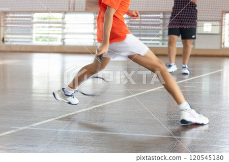 Playing badminton in a gym Playing badminton in a gym 120545180