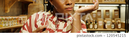 Woman Enjoying Aromas in a Cozy Store Environment 120545215