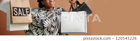 Smiling Woman Holding Shopping Bags While Bargain Hunting Smiling Woman Holding Shopping Bags While Bargain Hunting 120545226