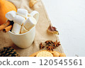 Warm autumn scene with hot chocolate, marshmallows, spices, leaves, and cozy sweater. Perfect for seasonal content. 120545561