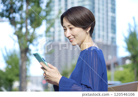 操作智慧型手機的女性，40 多歲，辦公區 120546106