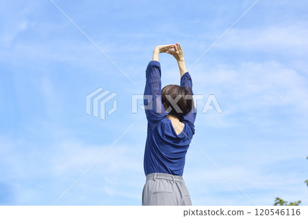 Woman stretching outside, back view Woman stretching outside, back view 120546116