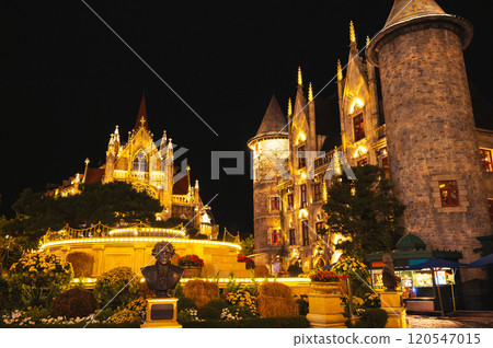 Catholic Cathedral and stone castle on central square of medieval city in Ba Na Hills Park in Da Nang in Vietnam at night 120547015