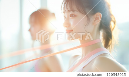 A woman uses a resistance band to train her neck at the gym 120548915