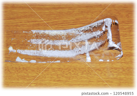 薄膜從酥餅上剝下來，折疊起來，放在木紋桌上，裡面黏著白色的奶油。 120548955