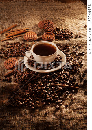 A cup of coffee on burlap and biscuits.Coffee cup with coffee bag on a wooden table. View from above. 120549488