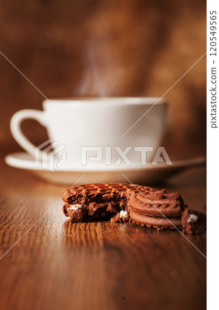 Broken cookies. Pieces of cookies.Warm coffee on a wooden plate backgrounds Broken cookies. Pieces of cookies.Warm coffee on a wooden plate backgrounds 120549565