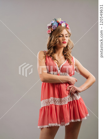 Charming girl.The woman is dressed in a pink dress. A wreath of flowers on her head. 120549631